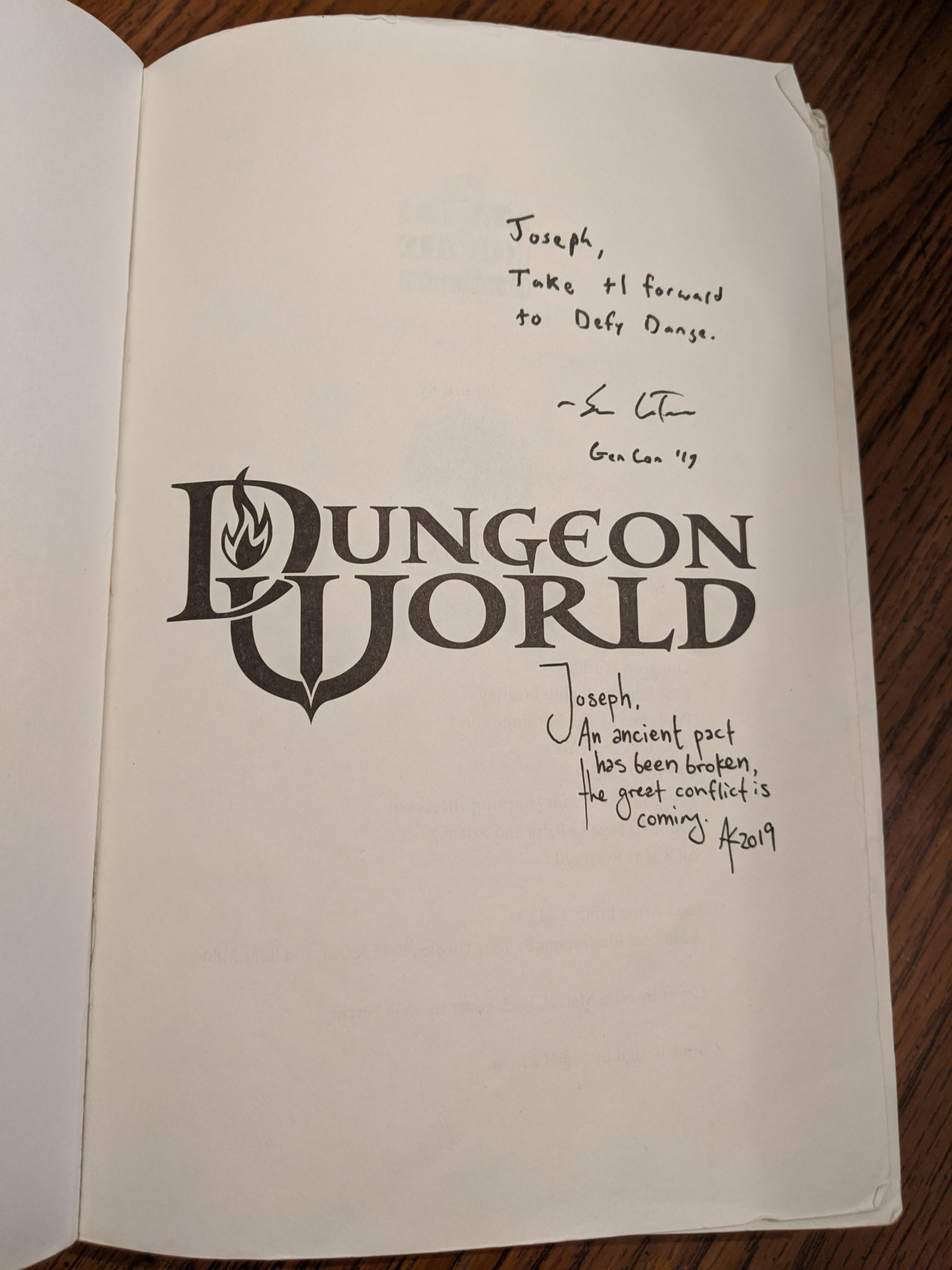 My copy of Dungeon world, signed by authors Adam Koebel and Sage LaTorra